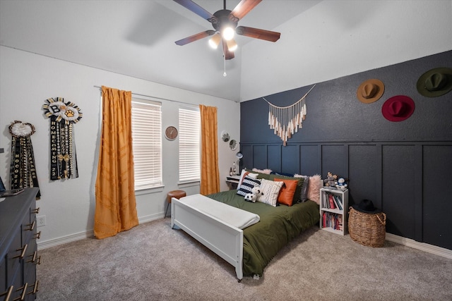 carpeted bedroom with lofted ceiling, ceiling fan, and a decorative wall