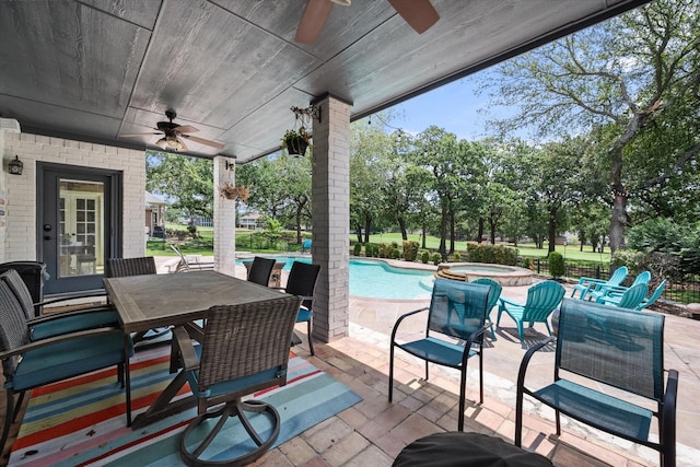 view of patio featuring outdoor dining space, a pool with connected hot tub, and a ceiling fan