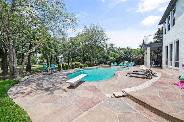 view of swimming pool featuring a diving board, a patio, fence, and a pool with connected hot tub