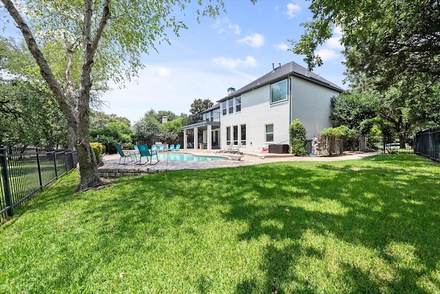 back of house featuring a patio, a lawn, a fenced backyard, and a fenced in pool