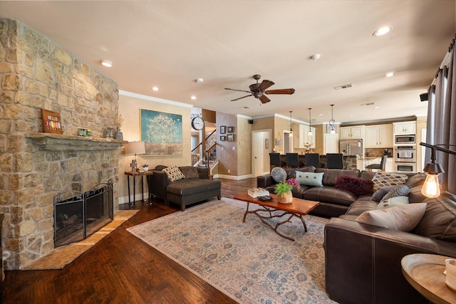 living room featuring crown molding, a fireplace, and wood finished floors