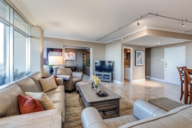 living room featuring visible vents, baseboards, ornamental molding, and track lighting