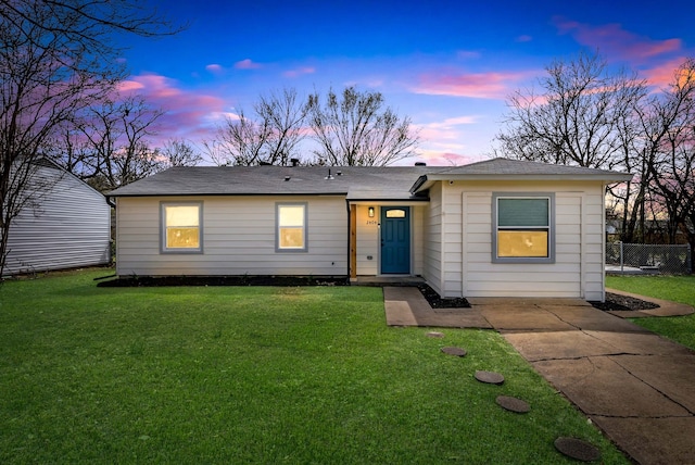 ranch-style home with fence and a lawn