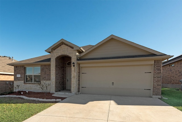 ranch-style home with stone siding, concrete driveway, an attached garage, a shingled roof, and brick siding