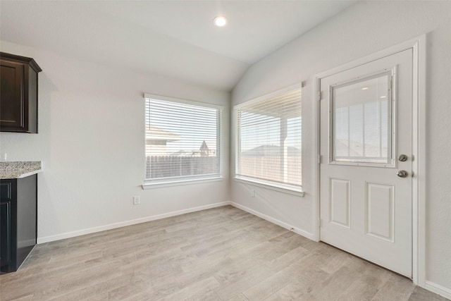 interior space featuring recessed lighting, light wood-type flooring, baseboards, and vaulted ceiling