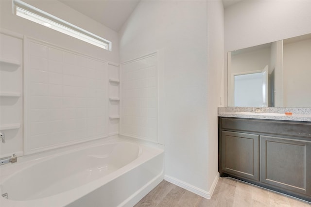 bathroom featuring baseboards, shower / washtub combination, wood finished floors, and vanity