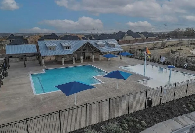 community pool featuring a patio and fence