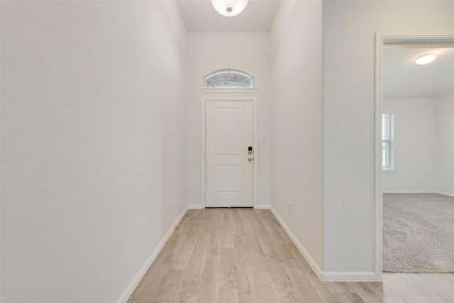 doorway to outside with light wood-style floors and baseboards