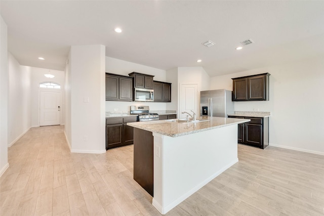 kitchen featuring visible vents, a sink, dark brown cabinetry, appliances with stainless steel finishes, and light wood-type flooring