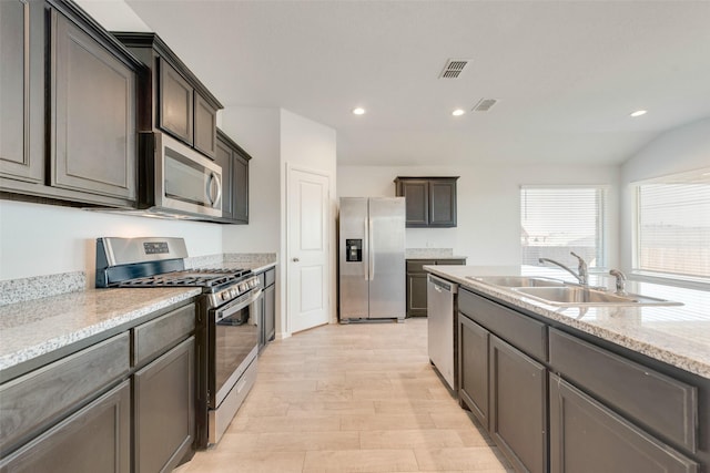 kitchen with visible vents, a sink, light stone counters, recessed lighting, and stainless steel appliances