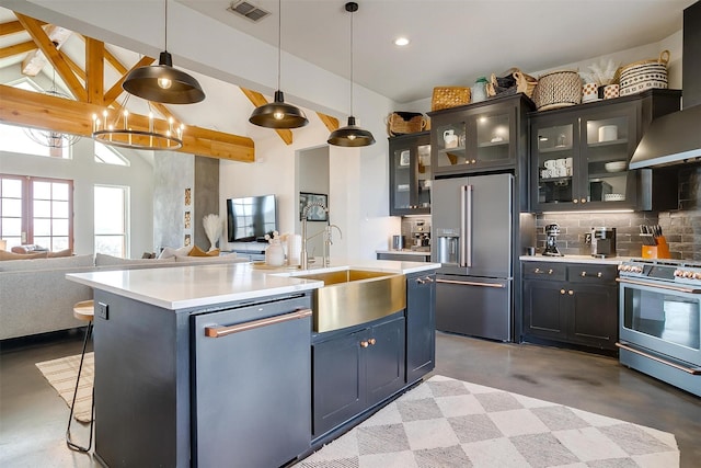 kitchen featuring visible vents, appliances with stainless steel finishes, wall chimney range hood, tasteful backsplash, and open floor plan