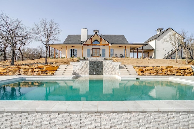 outdoor pool featuring french doors and stairs