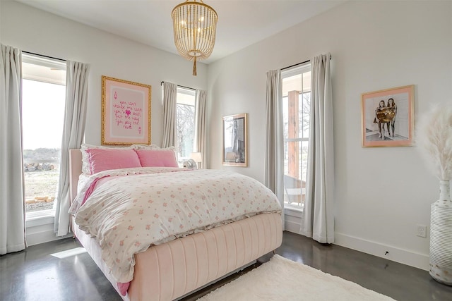 bedroom with baseboards and an inviting chandelier