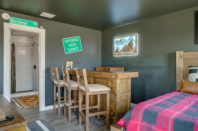 bedroom featuring visible vents, baseboards, and wood finished floors