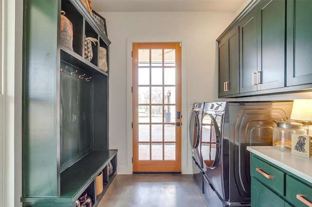 washroom with a healthy amount of sunlight, cabinet space, and washing machine and clothes dryer