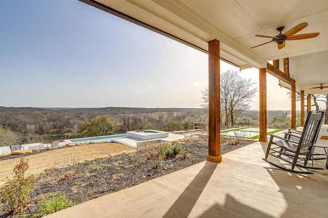 view of patio / terrace featuring an in ground hot tub, an outdoor pool, and a ceiling fan