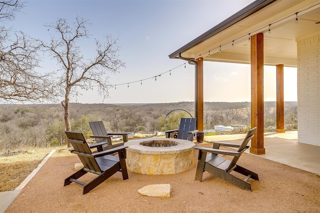 view of patio / terrace featuring a fire pit and a forest view