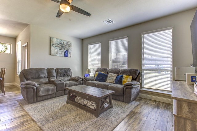 living room with a wealth of natural light, wood finished floors, and visible vents