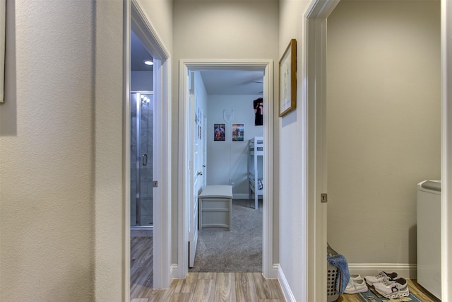 corridor with wood finished floors and baseboards