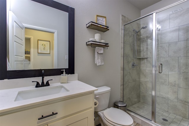 bathroom featuring a stall shower, vanity, and toilet