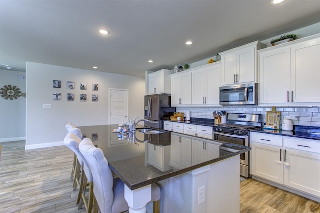 kitchen with white cabinetry, tasteful backsplash, appliances with stainless steel finishes, and a sink