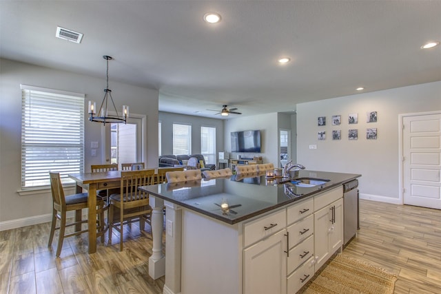 kitchen featuring light wood finished floors, recessed lighting, visible vents, stainless steel dishwasher, and a sink