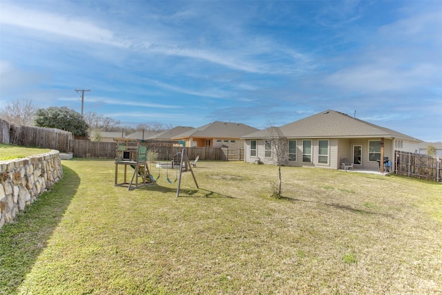 rear view of property with a fenced backyard, a lawn, a playground, and a patio