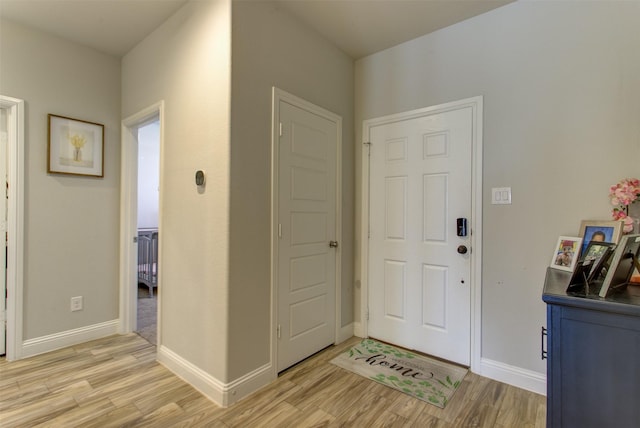 foyer entrance featuring light wood-type flooring and baseboards