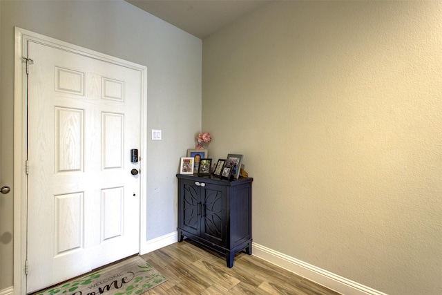 foyer entrance with wood finished floors and baseboards