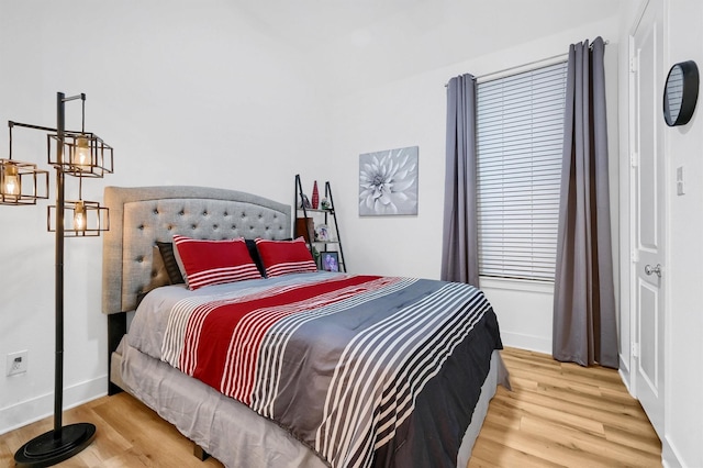 bedroom featuring baseboards and wood finished floors