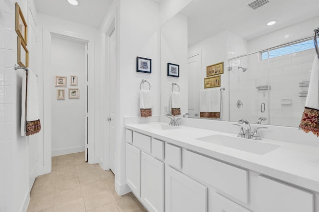 bathroom featuring tile patterned flooring, a shower stall, visible vents, and a sink