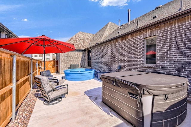 view of patio / terrace featuring a hot tub and a fenced backyard