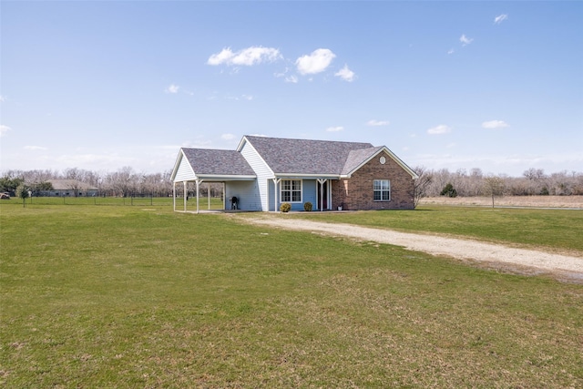 view of front of house featuring a carport, a front yard, brick siding, and roof with shingles