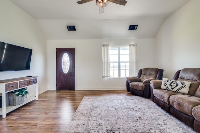 living room with a ceiling fan, lofted ceiling, baseboards, and wood finished floors