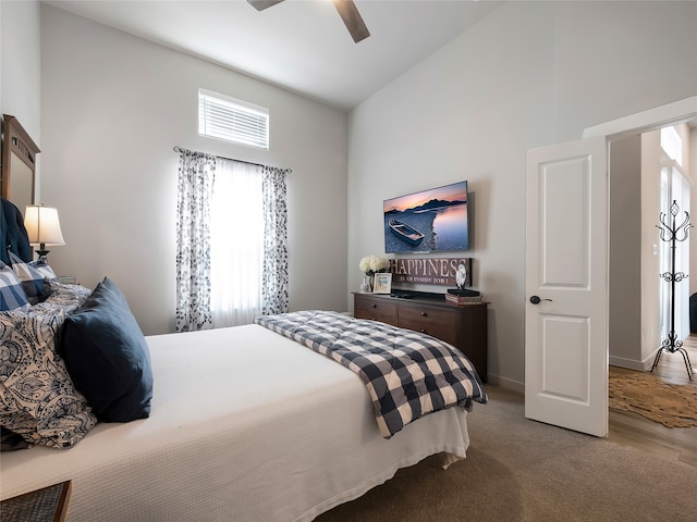 carpeted bedroom with high vaulted ceiling, baseboards, and a ceiling fan