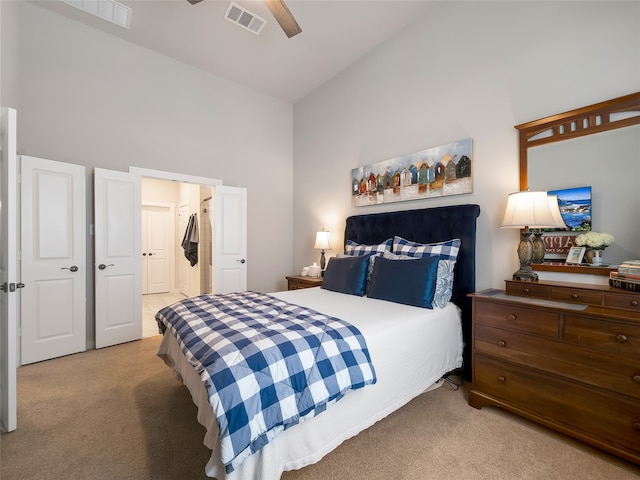 carpeted bedroom with high vaulted ceiling, visible vents, and a ceiling fan