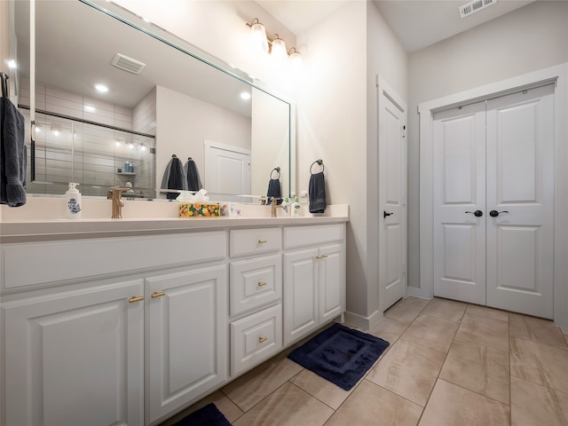 bathroom with double vanity, tile patterned flooring, a shower stall, and visible vents