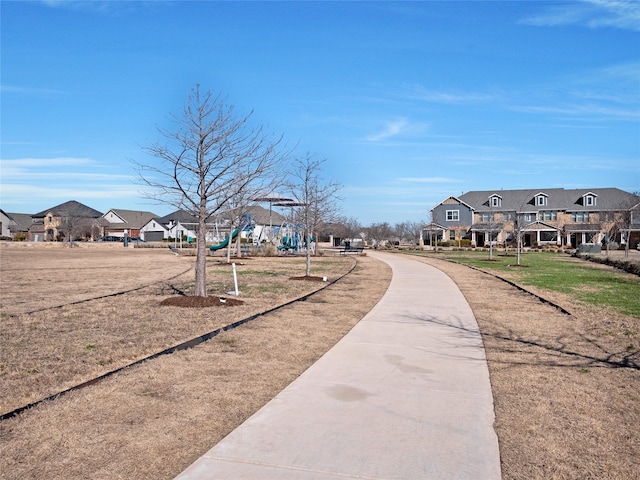 view of community with a residential view, a lawn, and playground community