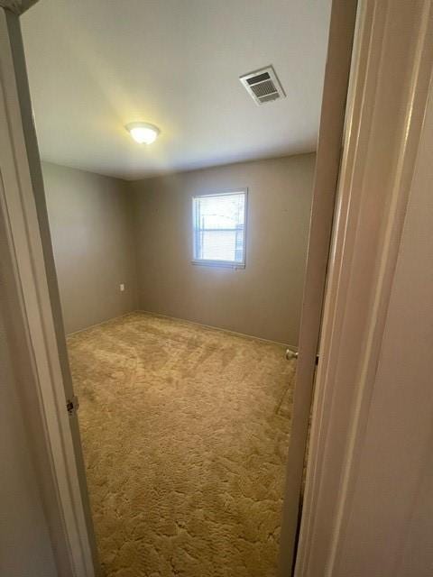 unfurnished room with carpet and visible vents