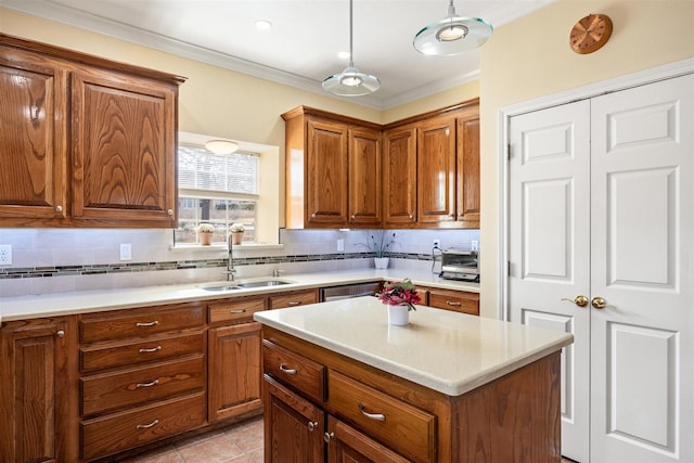 kitchen featuring tasteful backsplash, brown cabinetry, a sink, and crown molding