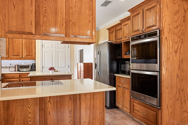 kitchen with black appliances, ornamental molding, visible vents, and brown cabinets