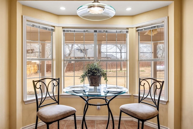 tiled dining space with recessed lighting and baseboards