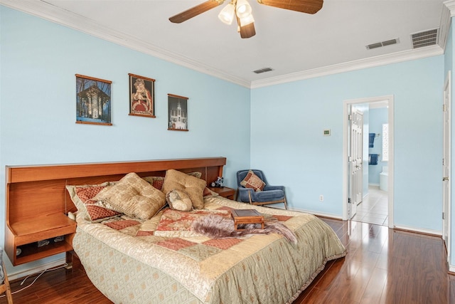 bedroom featuring visible vents, crown molding, and wood finished floors