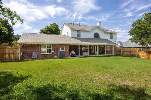 9705 Whitney Ct, Granbury, TX 76049 - back of property featuring central AC unit, brick siding, a patio area, a chimney, and a shingled roof