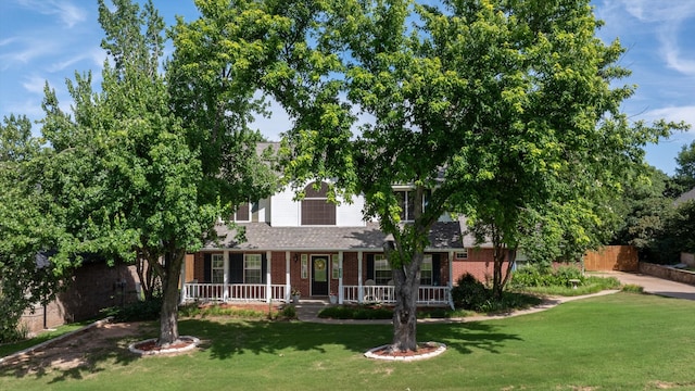 9705 Whitney Ct, Granbury, TX 76049 - view of property hidden behind natural elements featuring brick siding, a front yard, and a porch
