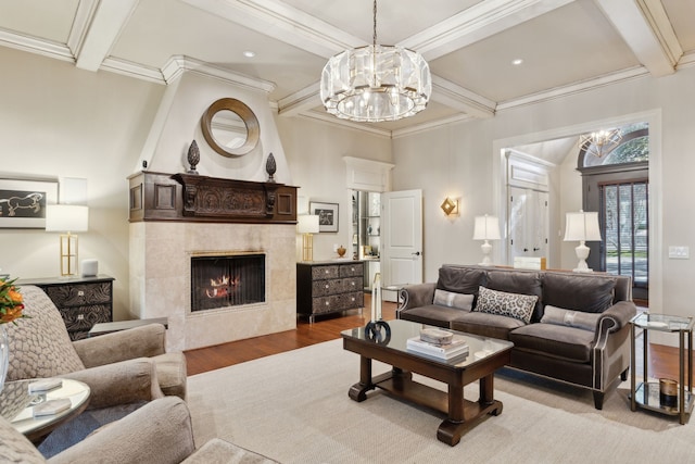 living room featuring a notable chandelier, a fireplace, wood finished floors, ornamental molding, and beam ceiling