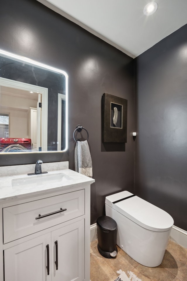 half bathroom with toilet, baseboards, and vanity