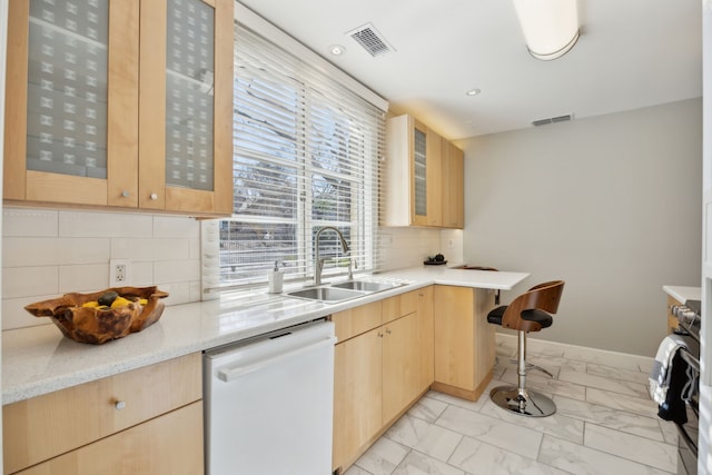 kitchen featuring marble finish floor, visible vents, white dishwasher, and a sink