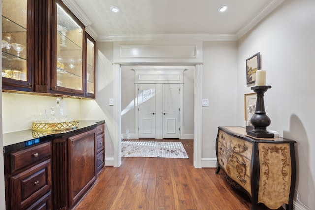 entryway featuring ornamental molding, dark wood finished floors, and baseboards