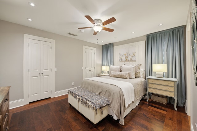 bedroom featuring baseboards, dark wood-type flooring, recessed lighting, and multiple closets